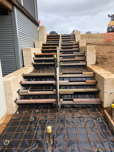 Concrete stairs being built beside a home