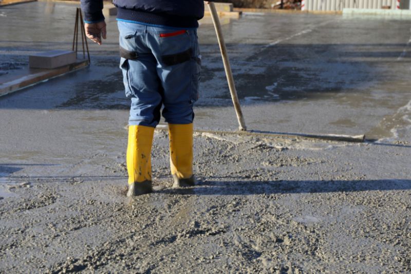 concrete worker levelling freshly poured concrete on the floor